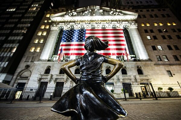a statue of a girl stands in defiance on WallStreet