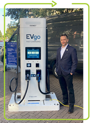 photo of Colin Murchie standing next to an EVgo charging station
