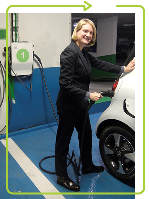 photo of Hilary Maxson standing and ready to insert a charger into a car