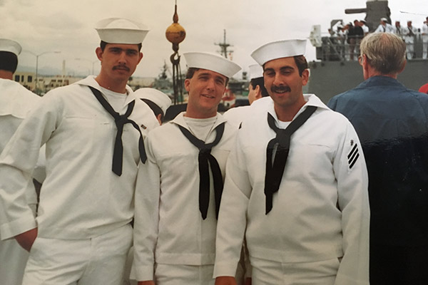 three young men dressed in US Navy sailor outfits, side by side