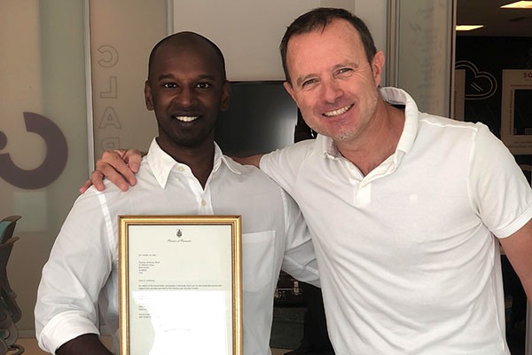 Pradeep Ambrose and Stuart Lacey standing and smiling with arms around each other's shoulders