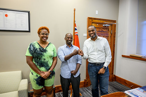 Carika Weldon, Pradeep Ambrose, and Premier Burt standing next to each other and smiling. Burt is giving Ambrose a fist bump