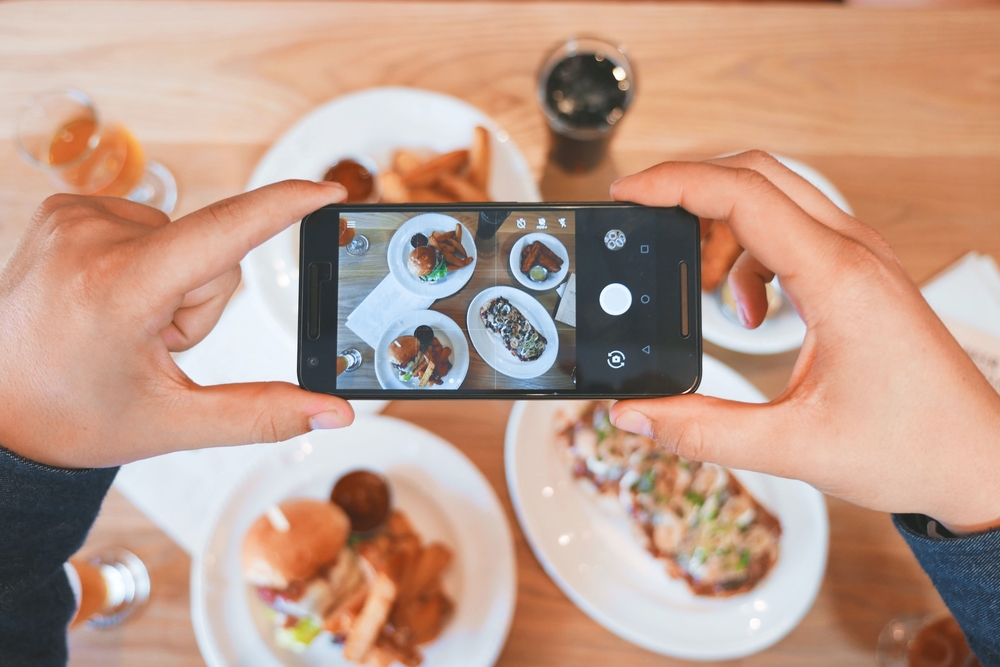 picture of cell phone taking a picture of plated food