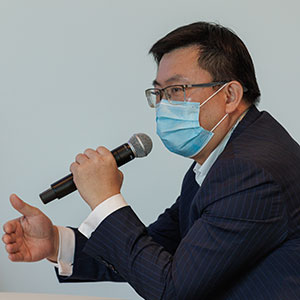 photo of Yuqiang Xiao hoding a mic and speaking