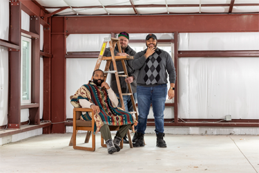 From left to right: Jeremiah Swain in chair, Ryan Goble behind ladder, and Cameron Scott pose in their facility. Photography by Jesse Winter