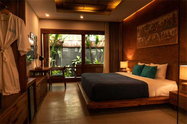 hotel room with bed and porch with tropical plants