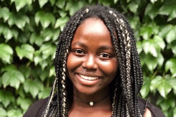 Jenniviv Bansah smiles in front of greenery