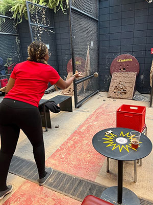 Ivy Ochieng throwing a tejo disk at a clay target.