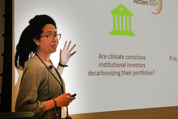 A female professor addresses a group in a lecture hall.