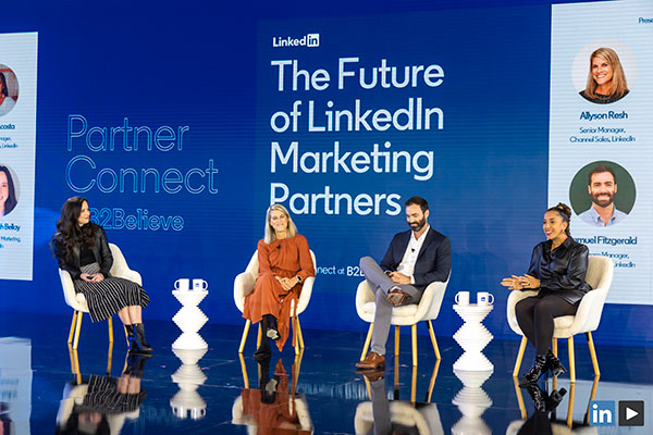 3 women and 1 man sitting on a stage with signage in the background, ""The Future of LinkedIn Marketing Partners".