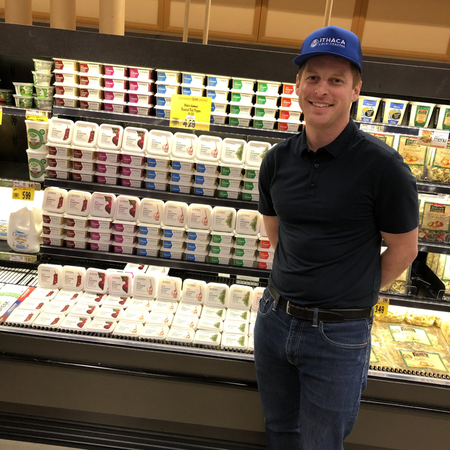 Chris Kirby, founder and CEO of Ithaca Hummus, stands in front of a display in a Wegmans grocery store