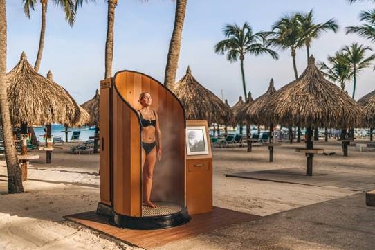 SnappyScreen machine on a beach with tiki huts in the background