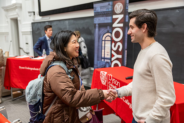 a student shaking hands with Steven Izen at the front of a lecture hall.