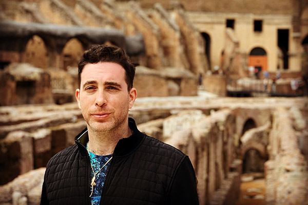 a man standing inside the Roman Colosseum.