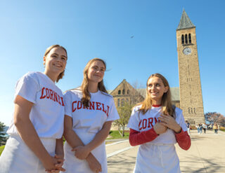 Three women students get ready for the Nolan School Server Derby in front of the clock tower.