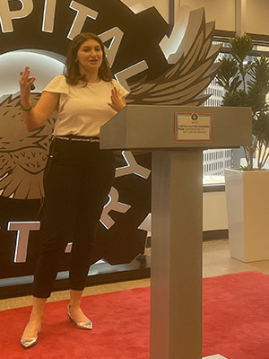 Danielle Boris standing at a podium and speaking.