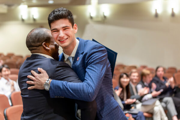 Lucas Suero ’26 hugs fellow competitor Christopher Browne, MPS '23 after winning the 13th annual hospitality business plan competition.
