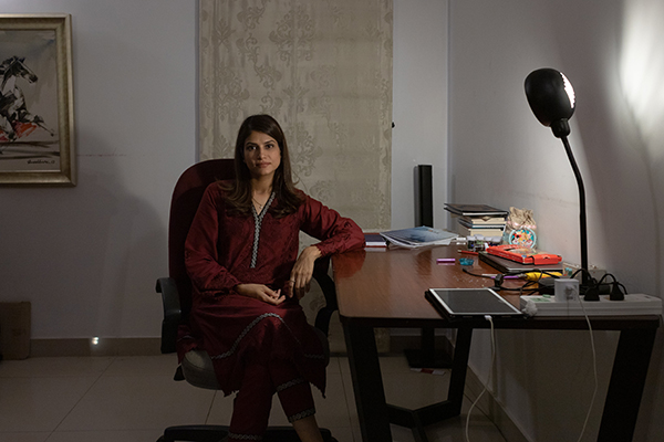 A woman seated next to a desk.