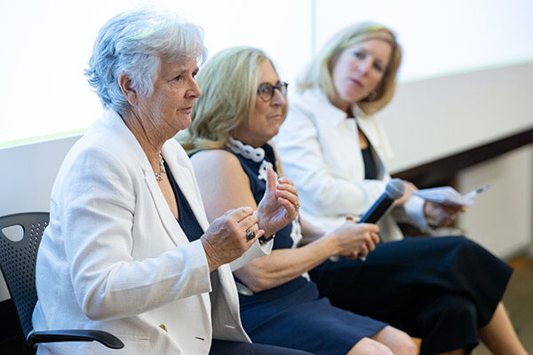 3 women sitting side by side with one speaking and gesturing.