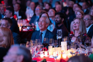 Danny Meyer sits among a crowd at a table with candles at the awards ceremony.