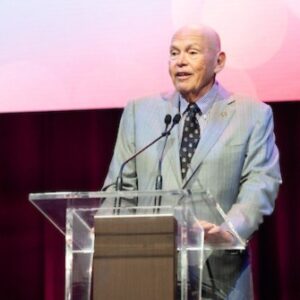 Lee Pillsbury '69 stands on stage at the podium at the 14th Annual Cornell Hospitality Icon and Innovator Awards.