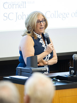 a woman holding a microphone and speaking.