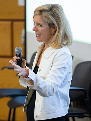 a woman speaking into a microphone and speaking.