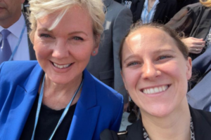 Courtney is to the right of Secretary of Energy Jennifer Granholm in a front-facing selfie photo at COP27. Other delegate attendees are in the background.