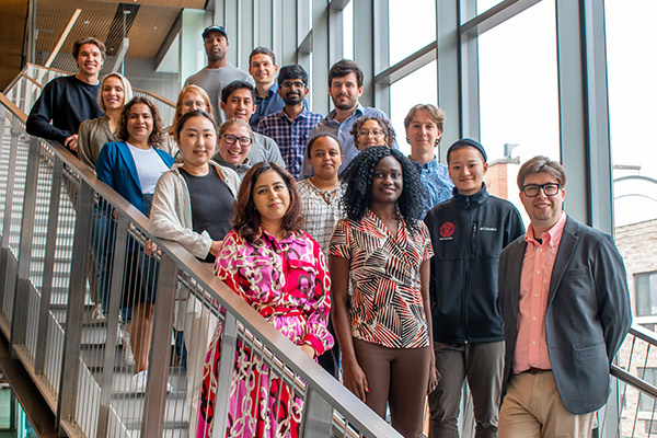 A group of 18 students poses on the stairs at the Breazzano Center.