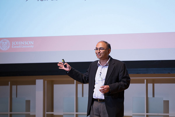 Vishal Gaur standing on a stage, speaking and gesturing.