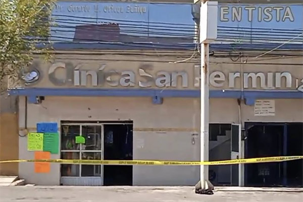 Photo of a run-down, closed private health clinic with yellow hazard tape around it.