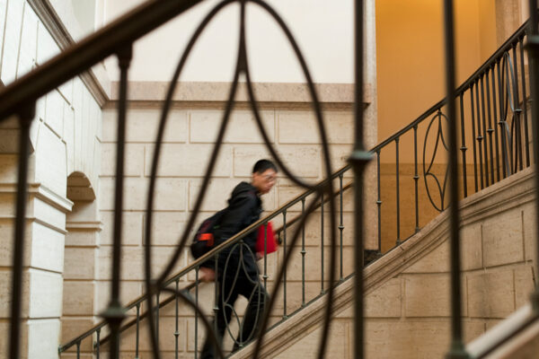 A student walks up stairs in Warren Hall.