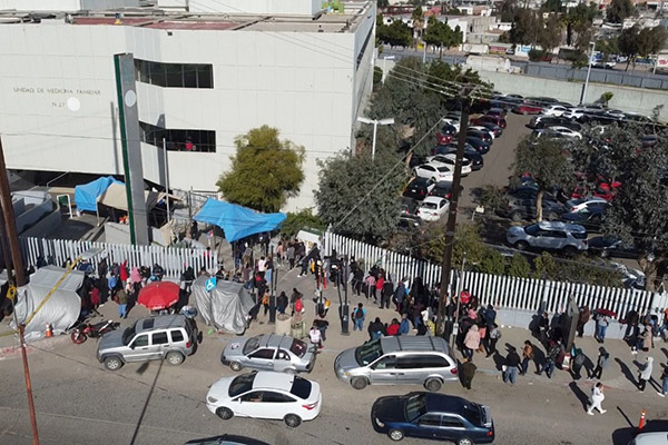 A line of people wrapping around a building.