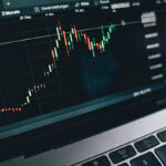 laptop computer screen graph showing daily fluctuations in Bitcoin value.