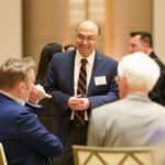Vishal Gaur stands with two conference attendees.