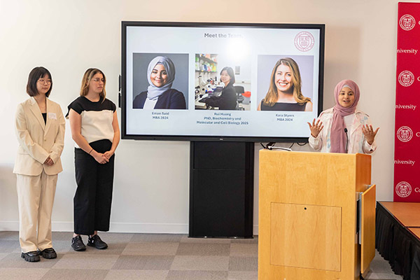 Eman Said, Rui Huang, and Kara Styers stand at the front of the room pitching at the Life Sciences Technology Innovation Fellowship Showcase.