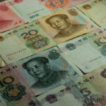 A tabletop covered with lots of different Chinese Renminbi bills.