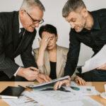Two men discussing projects with a frustrated female.