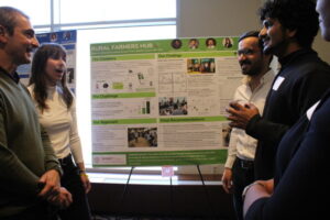 Students and faculty discuss a research poster.