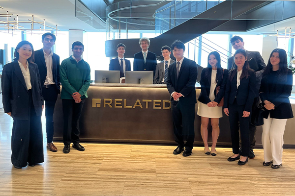 CREC student group poses near Related Companies welcome desk for picture in NYC