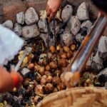 People Cooking Potatoes on Coals