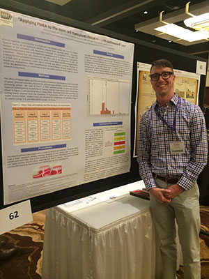 A man standin next to a poster filled with information.