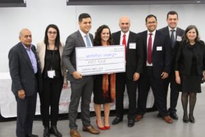 Case competition's winners posing for a picture with organizers and sponsors holding their prize check.