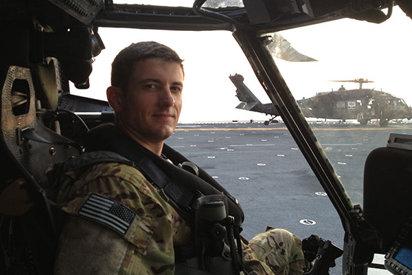 Shawn Driver sitting in a helicopter on an aircraft carrier flight deck.