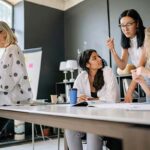 Office setting with four women collaborating.