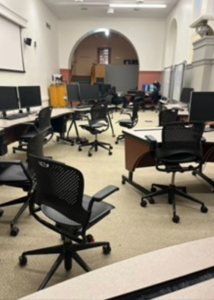 A room with computers and desk chairs scattered around. 