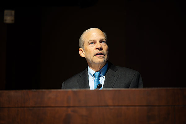 A man standing behind a podium and speaking.