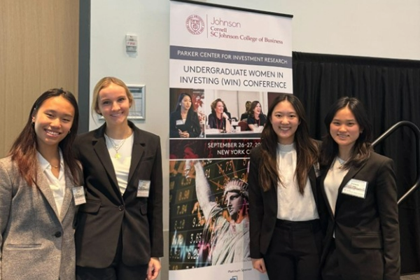 Grace Ou ‘27, Lucille Ley ’27, Amber Li ‘27, and Victoria Gong ‘25 pose by the 2024 Undergraduate Women in Investing Conference banner.