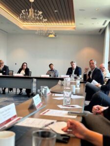 Image of professionals around a table engaged in conversation.