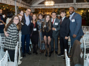 Group of people dressed professionally smile for the camera.